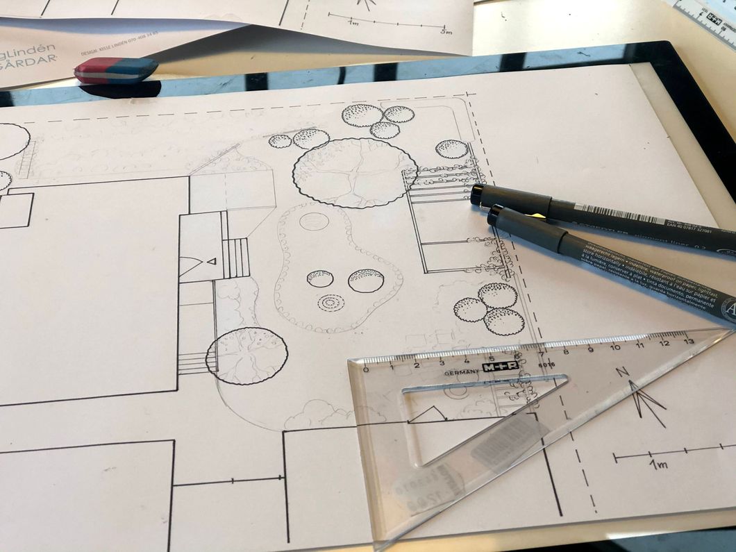 Planering av trädgård, ritad på papper, linjal och två svarta pennor